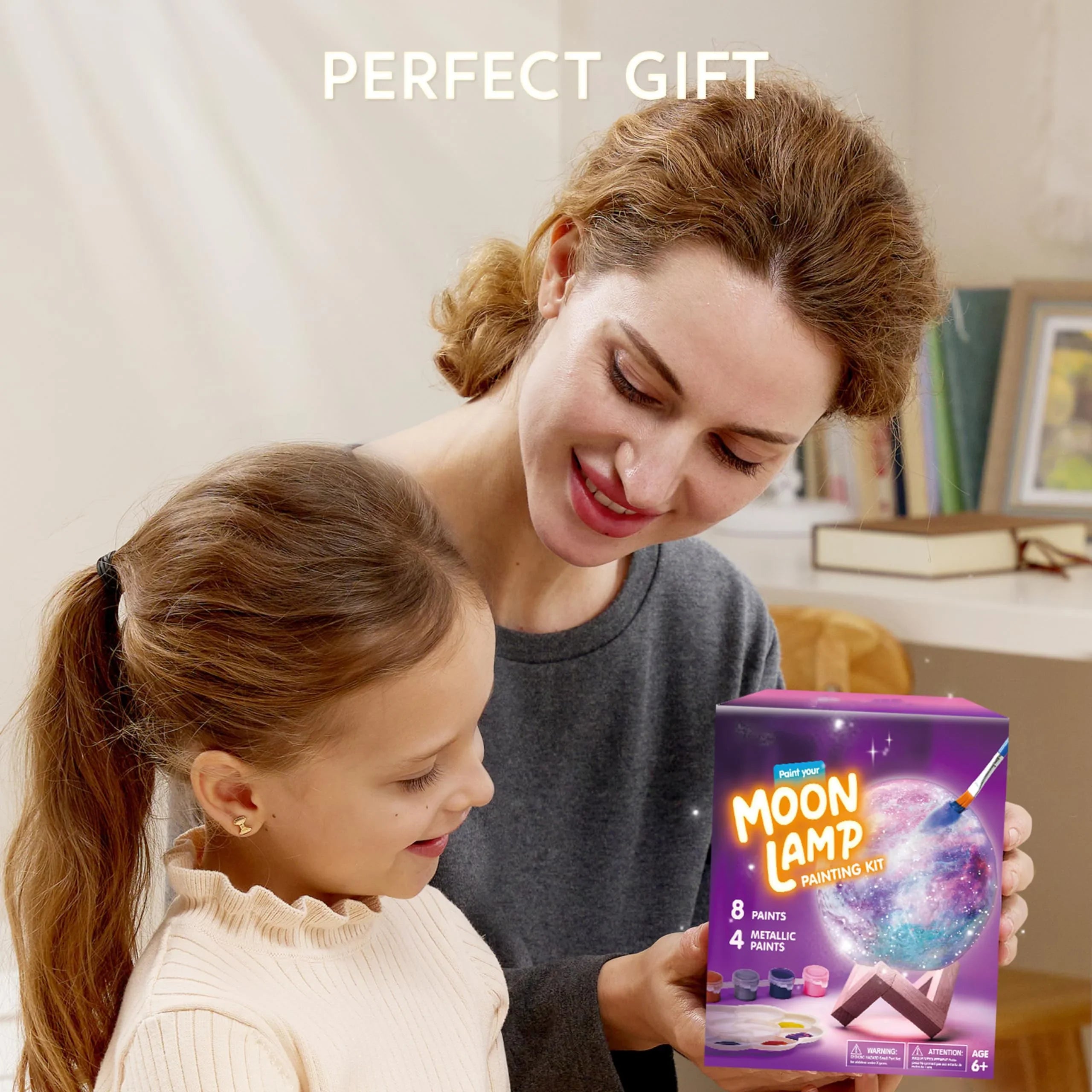 Mother and daughter smiling while holding a Moon Lamp painting kit, perfect gift for kids