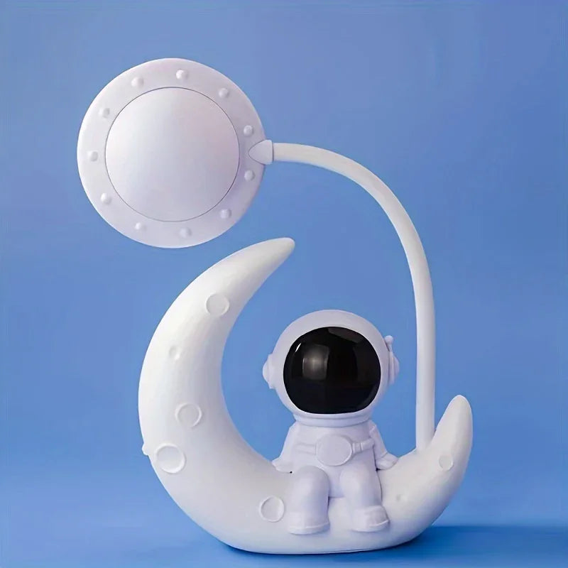 Cute astronaut lamp sitting on crescent moon, space-themed tech gadget on blue background.