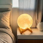 Moon lamp night light on wooden stand beside bed, modern bedroom decor accessory