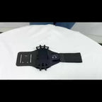 Black adjustable armband phone holder with elastic strap on a white surface, tech accessory.