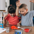 Two children excitedly exploring a STEM science kit experiment with growing heart model