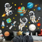 Kids bedroom with space-themed wall decals featuring astronauts, planets, rockets, and stars.