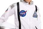 Child in white astronaut costume with NASA and space patches, holding a space helmet.