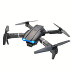 Foldable black drone with camera, four propellers, and blue LED lights on white background