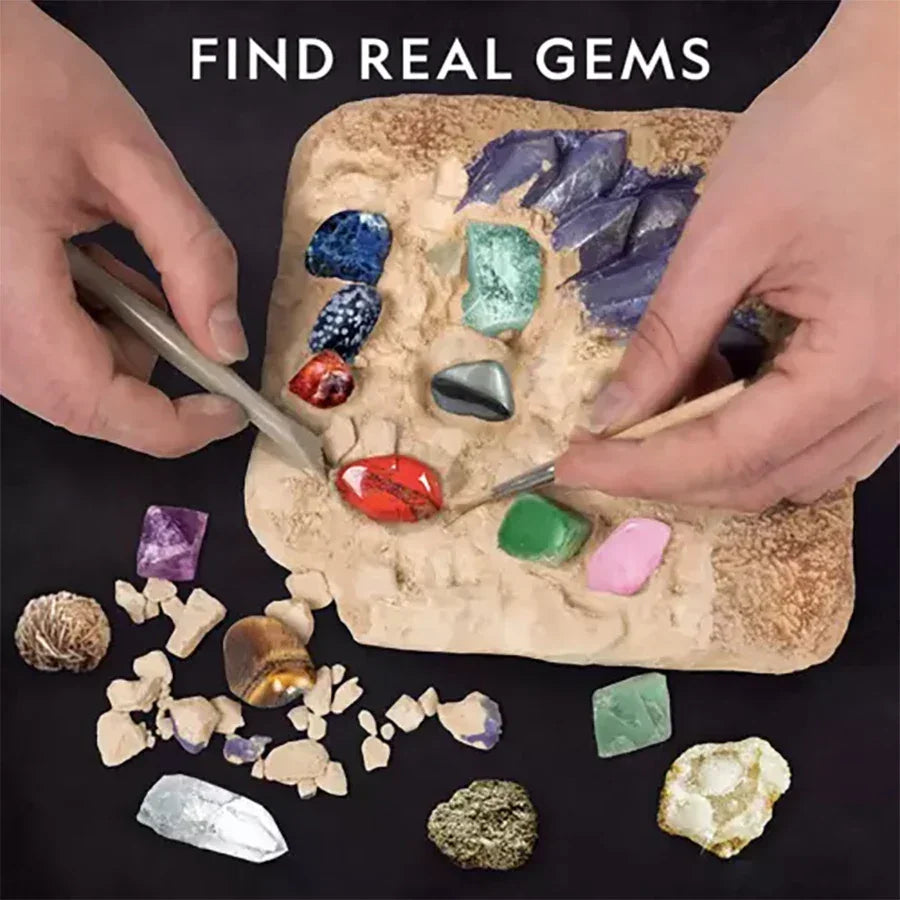 Hands excavating colorful real gemstones from a dig kit for kids with tools and stones.