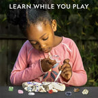 Child examining gemstones with magnifying glass, educational toy kit, STEM learning activity
